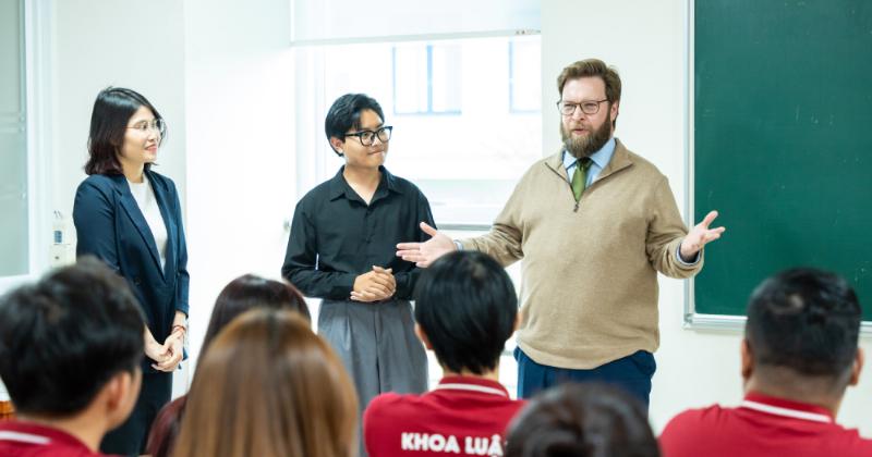 Chân dung một luật sư hoặc giảng viên chuyên ngành luật đang phát biểu hoặc chia sẻ kiến thức, thể hiện góc nhìn chuyên gia về tài liệu môn luật kinh tế