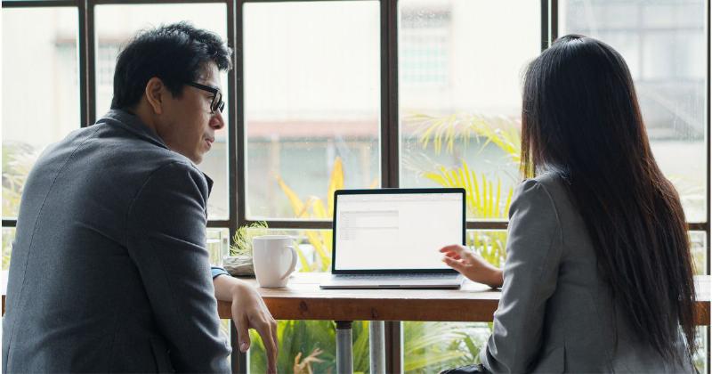 Một giáo viên đang ngồi ngang tầm với hai học sinh đang tranh cãi, lắng nghe cẩn thận và nói chuyện một cách bình tĩnh, thể hiện kỹ năng giải quyết xung đột thông qua giao tiếp.