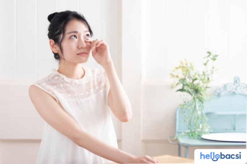 Một người ngồi thu mình trong góc phòng tối, khuôn mặt biểu lộ sự mệt mỏi và buồn bã sâu sắc, thể hiện rõ các dấu hiệu của trầm cảm