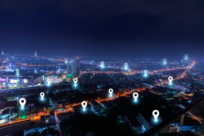 Hình ảnh một người dùng điện thoại xem bản đồ số để tìm đường trong thành phố, minh họa ứng dụng bản đồ trong đời sống hàng ngày